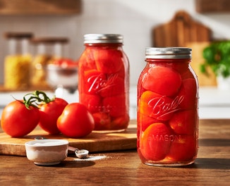 Glass canning jars with lids and bands preserving tomatoes